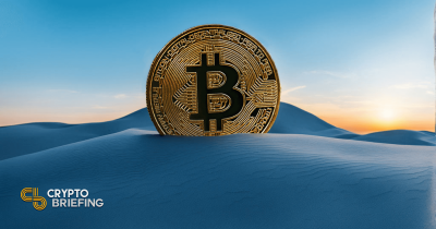 A large Bitcoin coin embedded in sand dunes under a clear sky at sunrise, symbolizing the digital currency's resilience and growth potential.