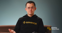 Changpeng Zhao (CZ), CEO of Binance, wearing a Binance hoodie, gesturing while seated for an interview.