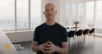 Brian Armstrong standing in a modern office, speaking with hands clasped.