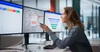 Person analyzing marketing dashboards on multiple monitors