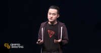 Justin Sun hablando en una conferencia de criptomonedas, vistiendo una camiseta con el logo de Tron (TRX) y gesticulando con sus manos.