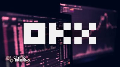 Logo de OKX mostrado prominentemente sobre un fondo de gráficos y estadísticas de operaciones criptográficas en monitores de computadora.