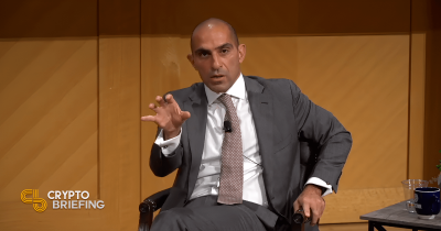 Rostin Behnam, presidente de la CFTC, hablando durante un panel de discusión, levantando la mano para hacer un punto.